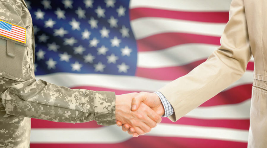 hire veterans - business and military handshake American flag in back